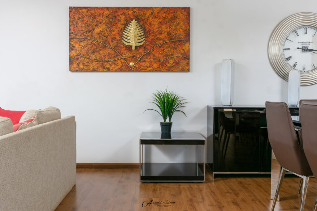 Living room with a beige sofa, framed artwork and wooden flooring