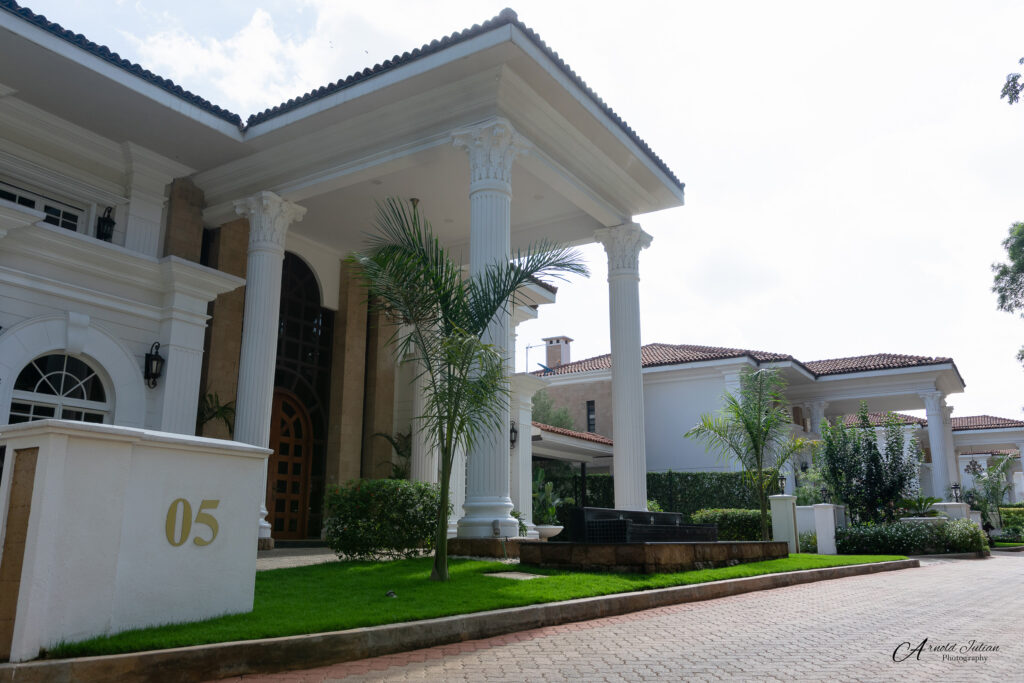 Exterior of a two storey residential house with columns and a landscaped garden