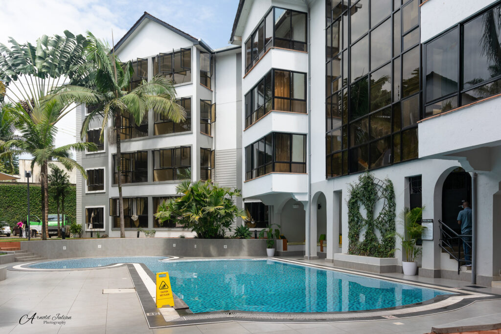 Apartment building exterior with a swimming pool and palm trees