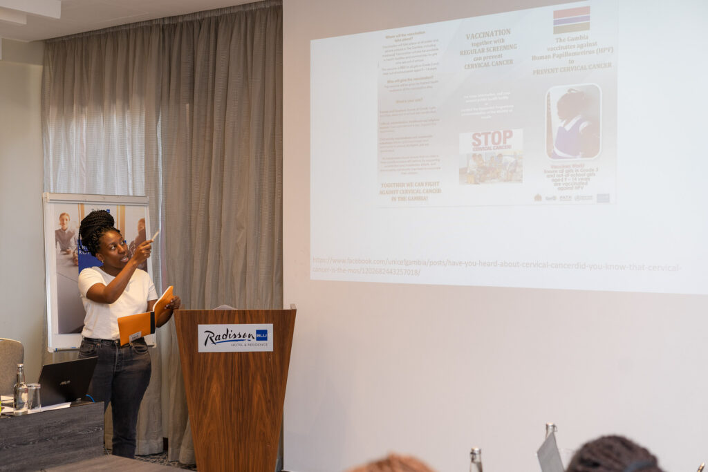 Presenter speaking beside a projection screen in a hotel meeting room