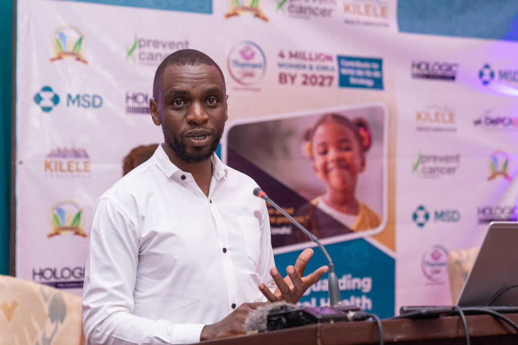 Speaker at a lectern in front of a cervical cancer awareness backdrop