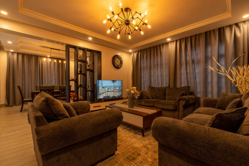 Warmly lit lounge with brown upholstered sofas and a chandelier
