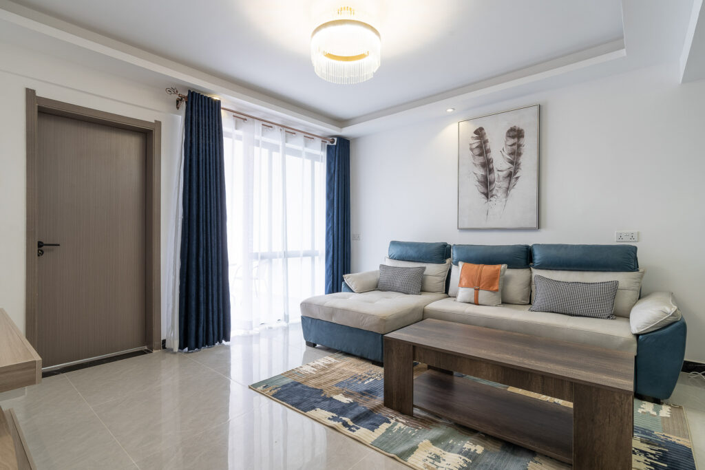 Living room with grey sofas, a patterned rug and blue curtains