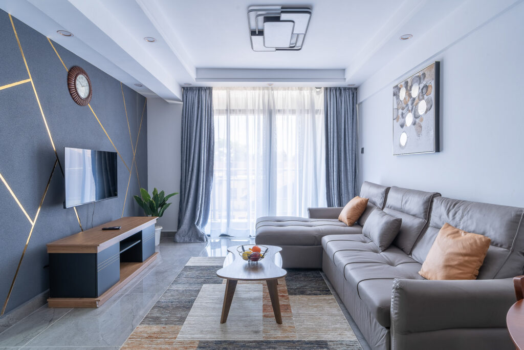 Modern living room with a grey corner sofa and wall mounted television