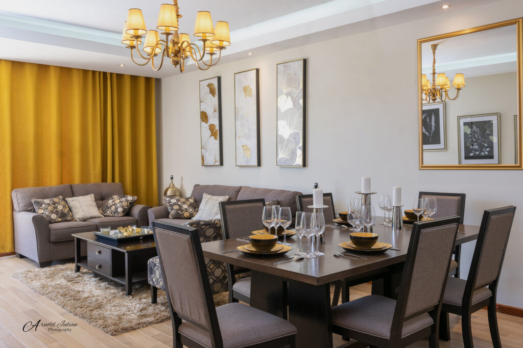 Dining area with a wooden table, yellow curtains and a chandelier