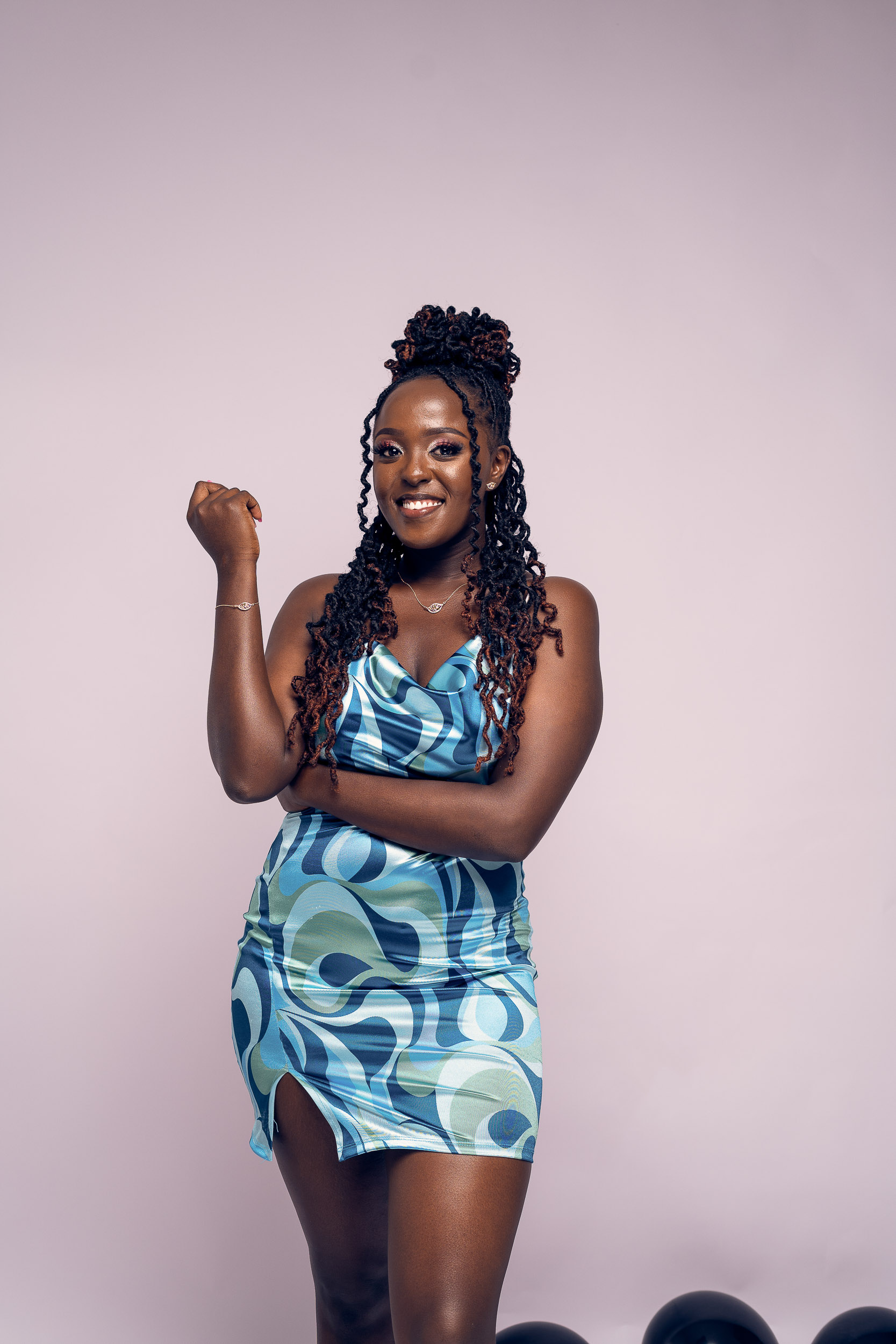 Studio portrait of a smiling woman in a blue and green patterned two piece outfit