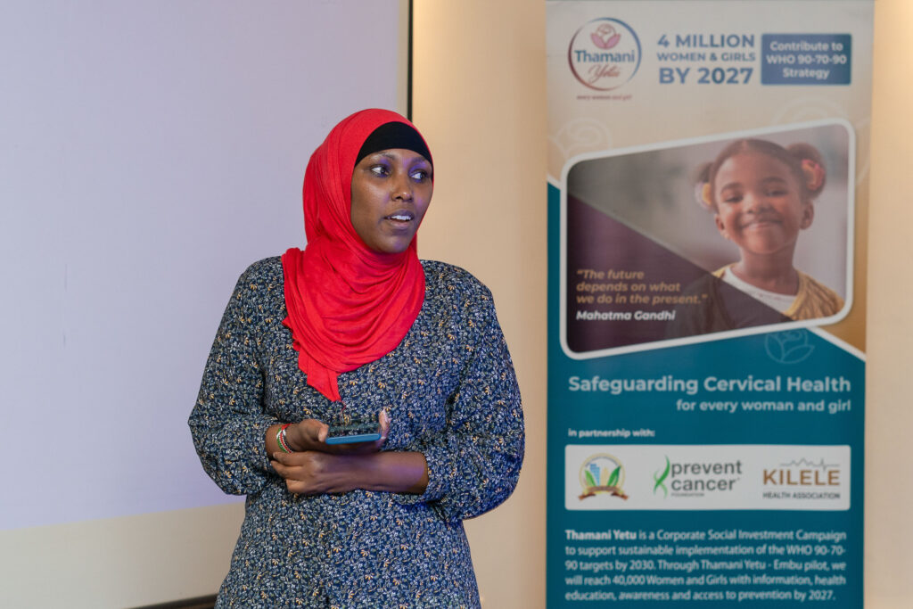 Speaker presenting beside a cervical health awareness banner