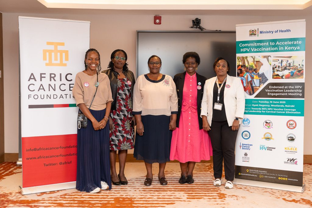 Five women posing in front of Africa Cancer Foundation banners
