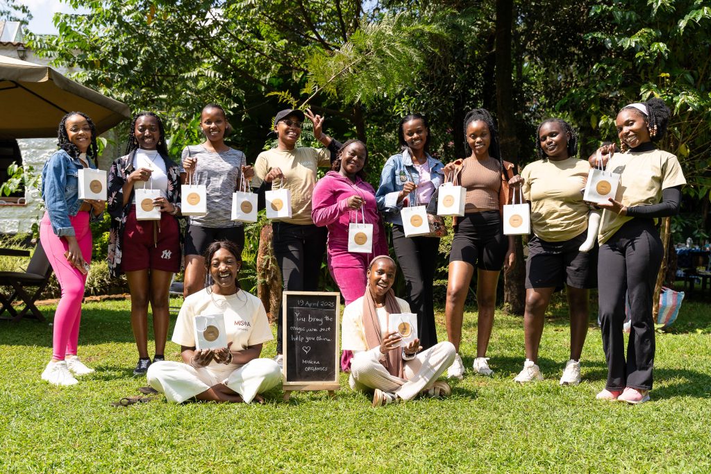Young women posing on a lawn holding small chalkboards